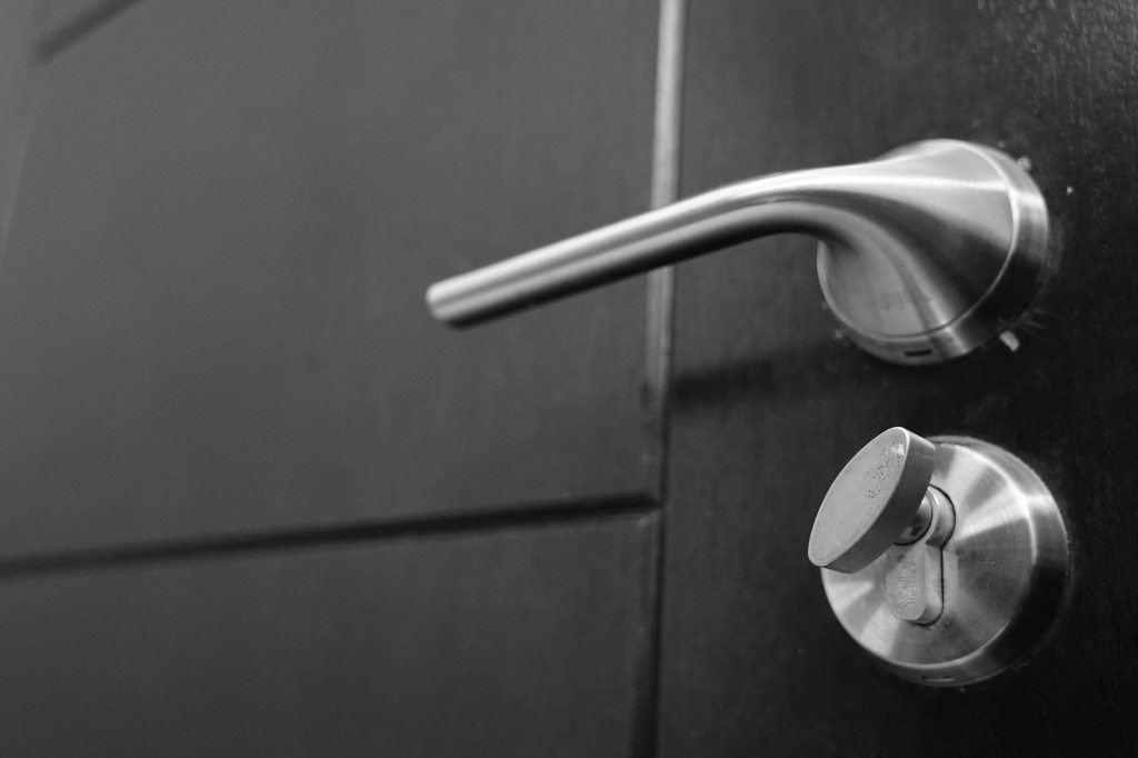silver doorknob and lock on black door